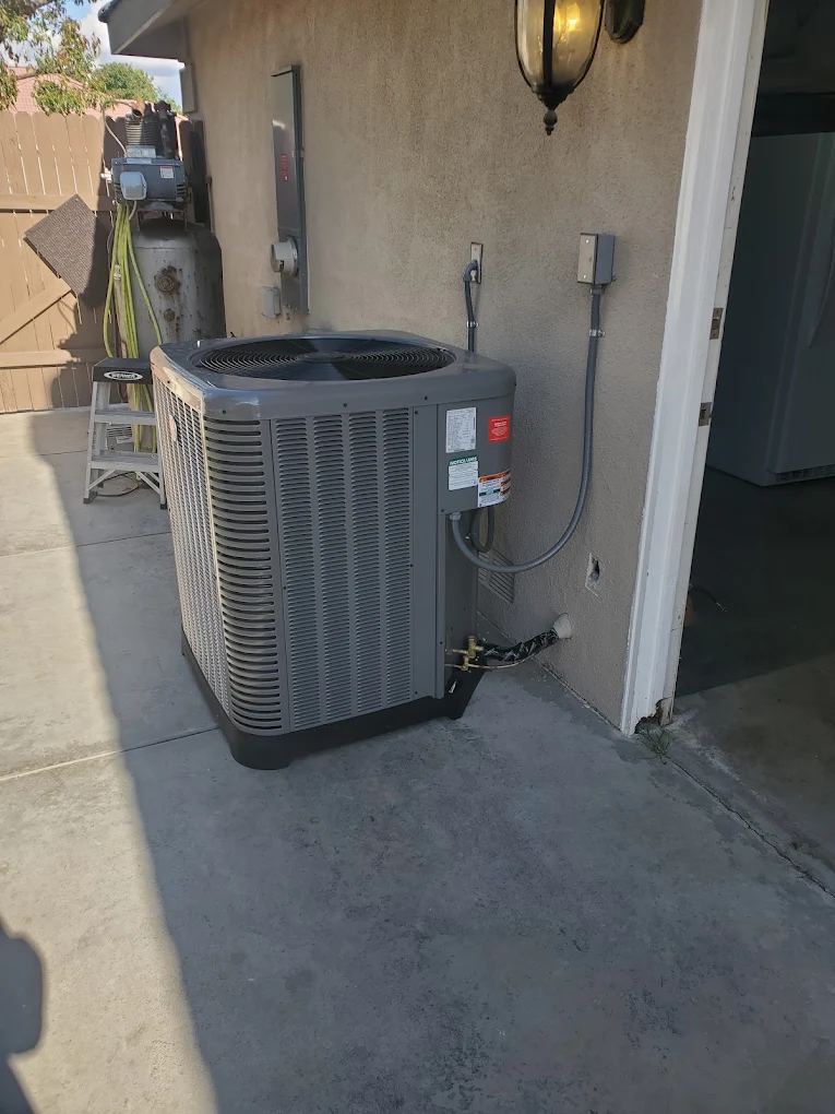 New air conditioner installed beside a stucco garage