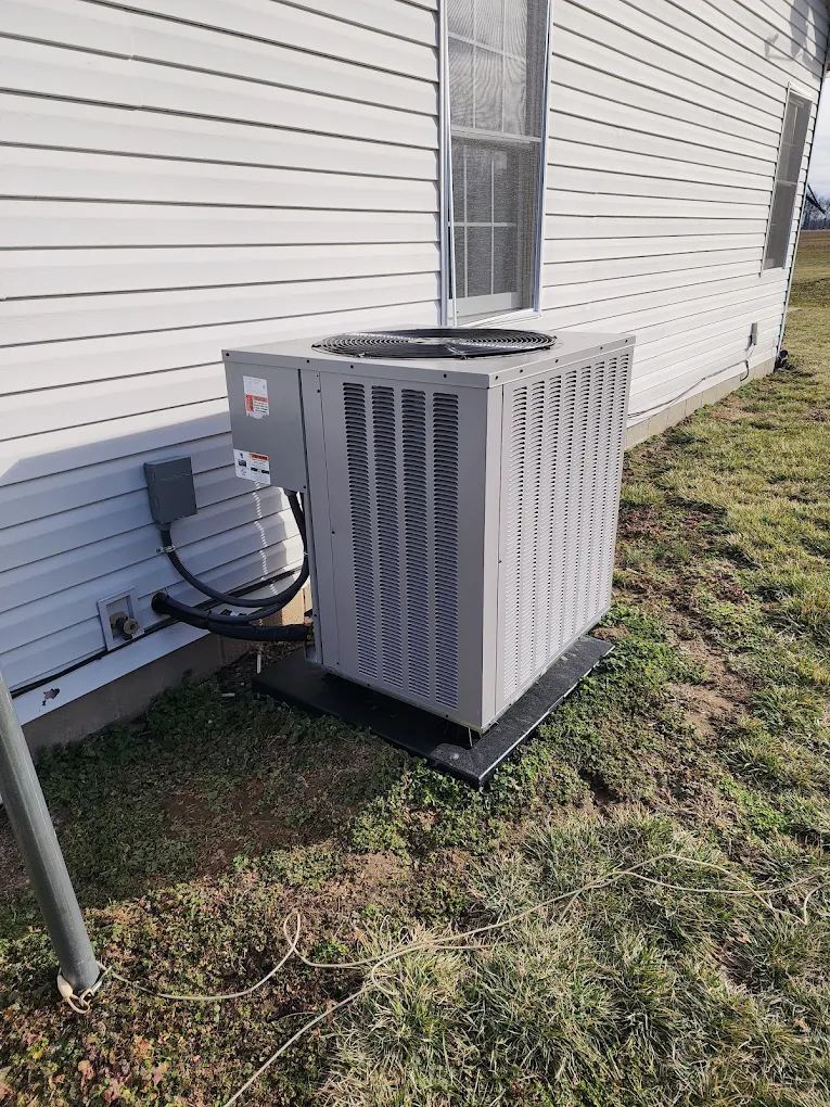 Air conditioner condenser installed at a vinyl-sided home