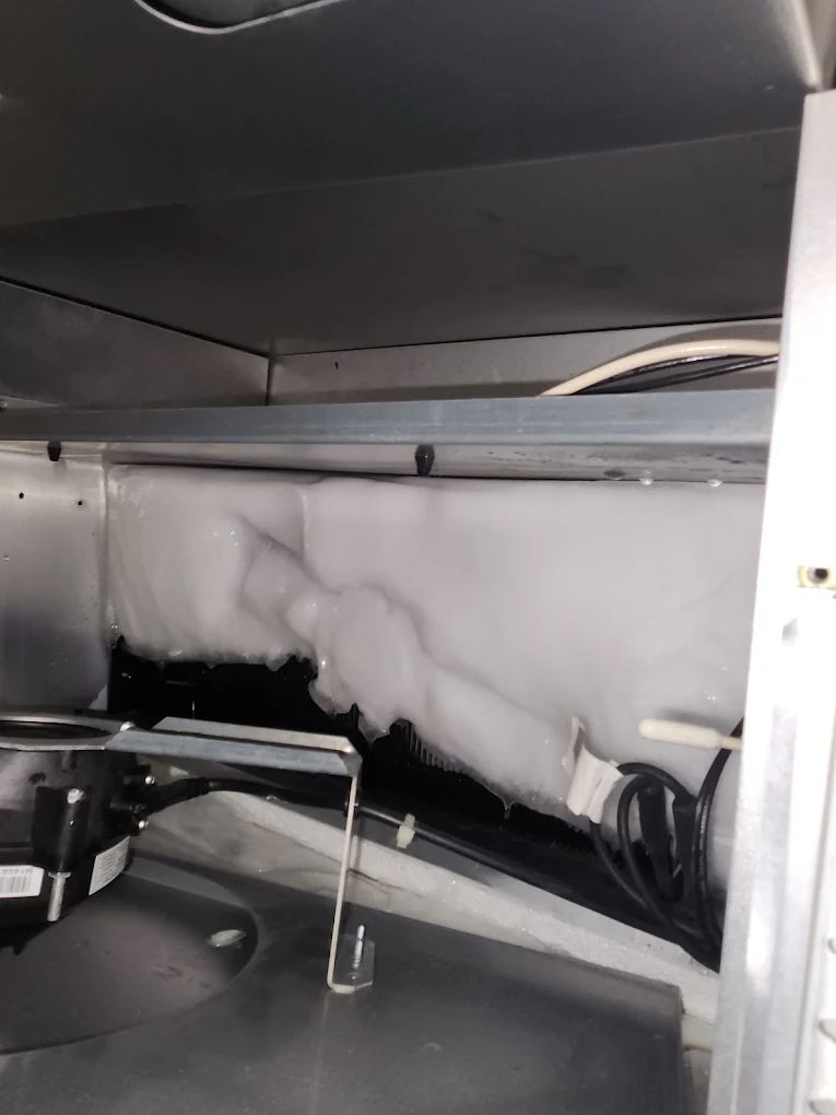 Iced-over evaporator coil in a commercial freezer — a defrost system failure JHC diagnoses and repairs