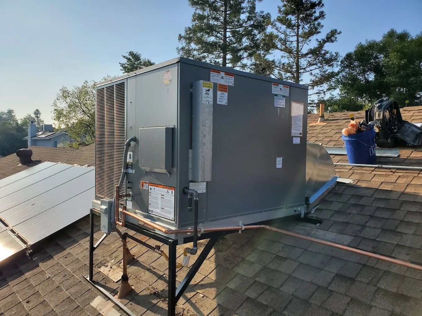 Rooftop package unit with copper gas line on a shingle roof